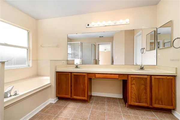 a spacious bathroom with a sink mirror and a bathtub