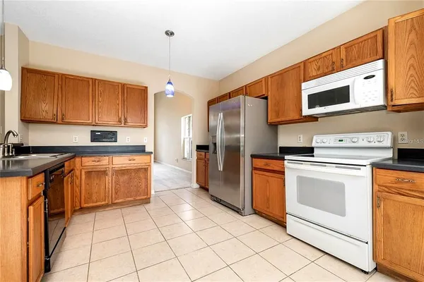 a kitchen with stainless steel appliances granite countertop a stove a sink and a refrigerator