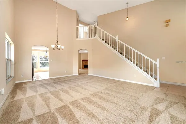a view of a big room with a chandelier fan and windows