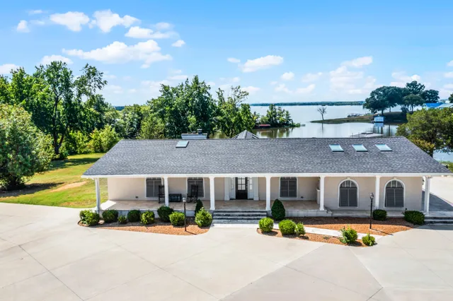 a front view of house with yard and trees in the background
