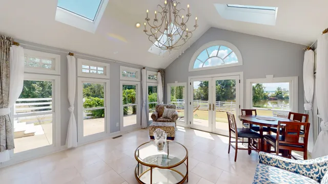 a living room with furniture a chandelier and a large window