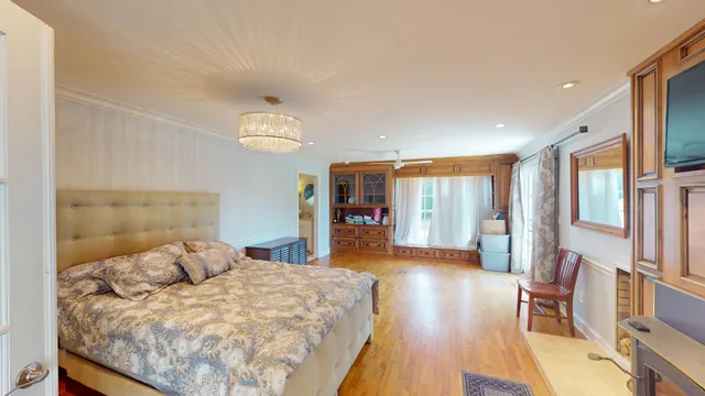 a large bedroom with a bed and wooden floor
