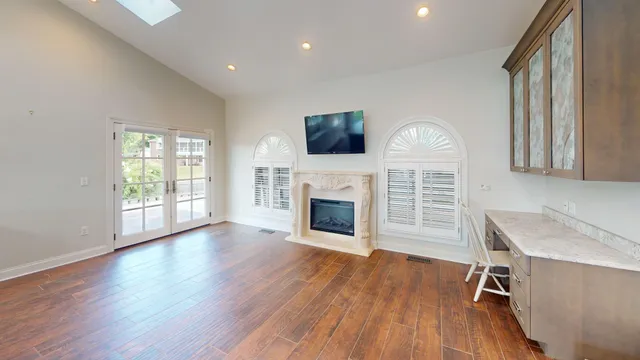 a large kitchen with kitchen island white cabinets and wooden floor