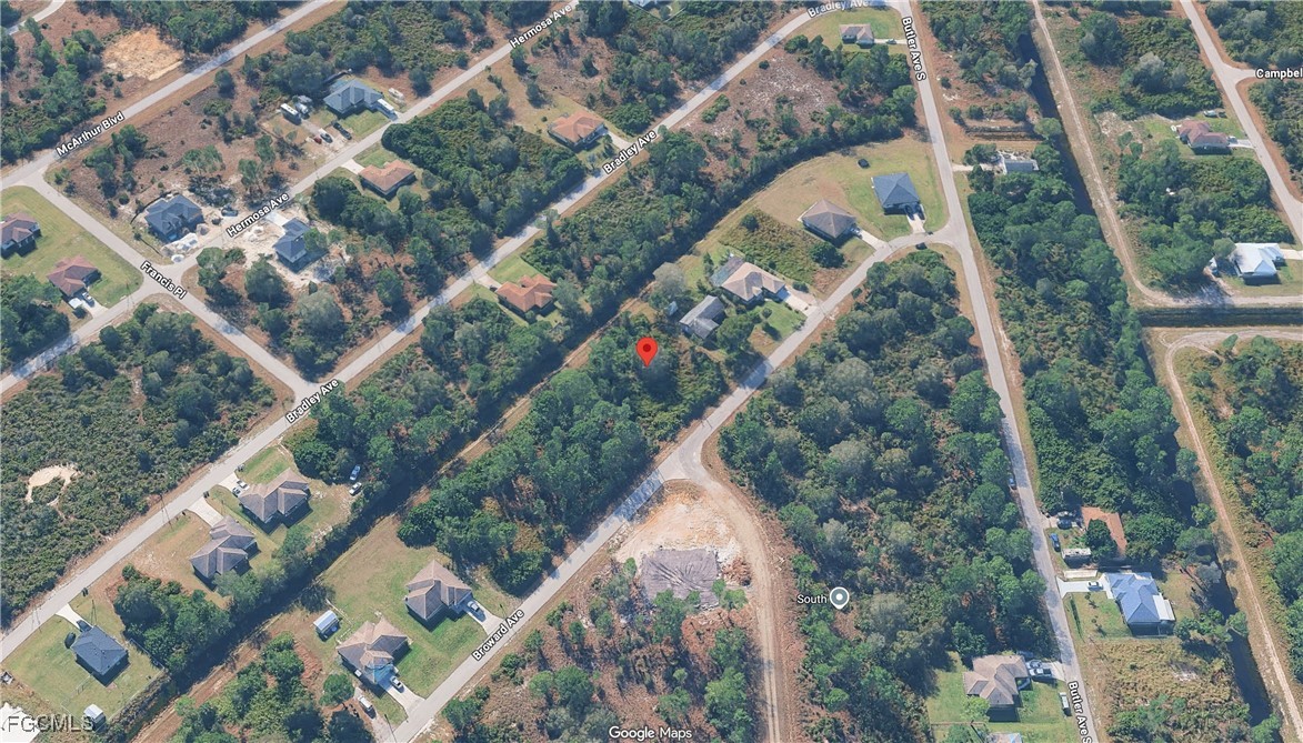 329 Broward Avenue Lehigh Acres, FL 33974 - Photo 5 of 9 an aerial view of a house with a yard and couple of flower plants