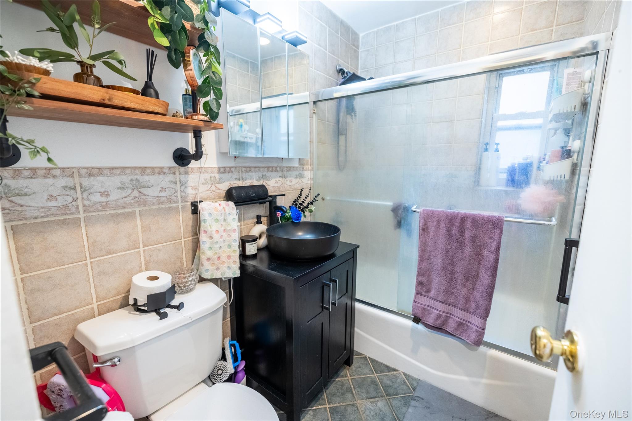 221 Middle Neck Road, Unit M2 Great Neck, NY 11021 - Photo 5 of 15 Bathroom with bath / shower combo with glass door, tile walls, vanity, and dark tile patterned flooring