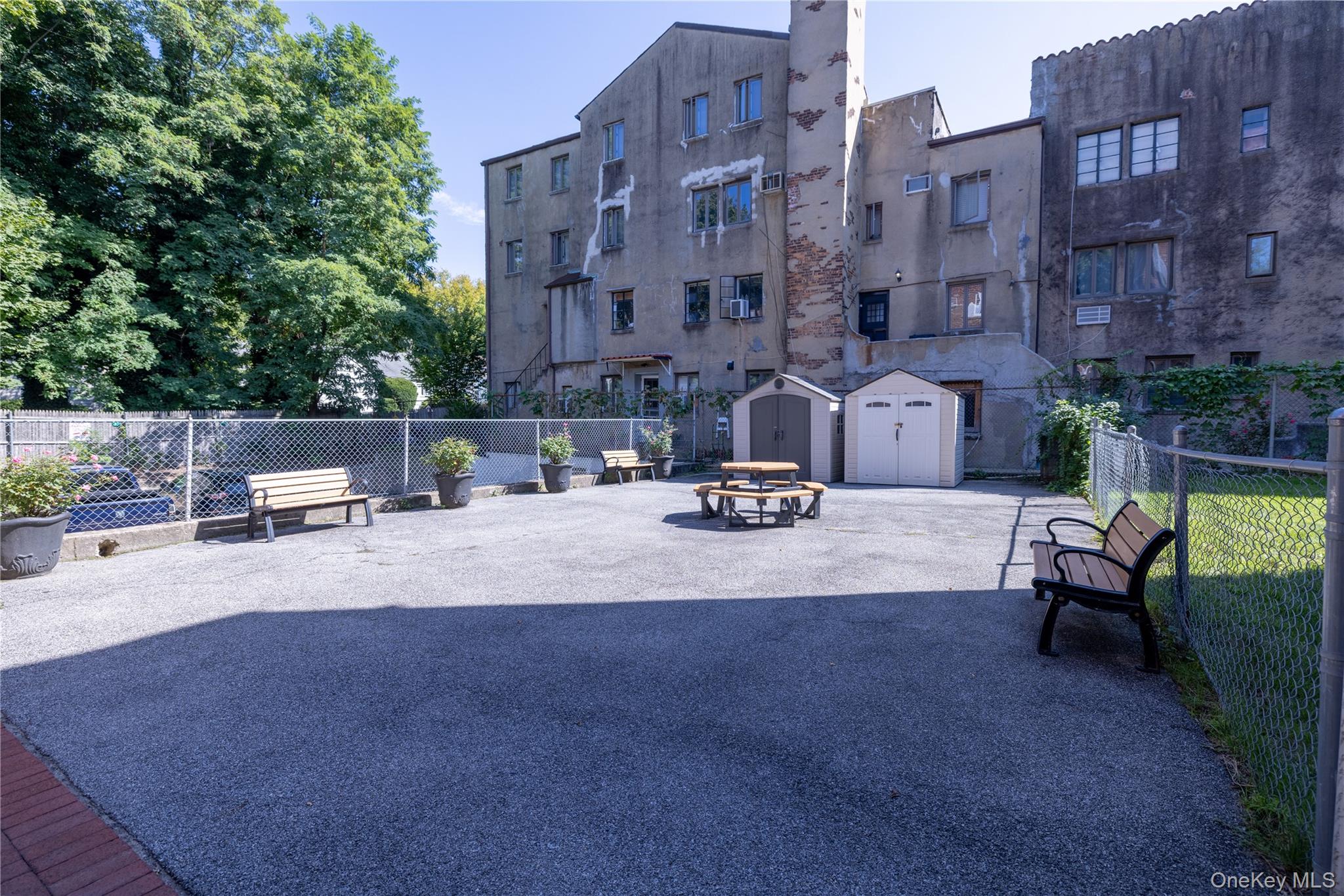 221 Middle Neck Road, Unit M2 Great Neck, NY 11021 - Photo 9 of 15 View of community with a storage shed, a fenced backyard, and a patio area
