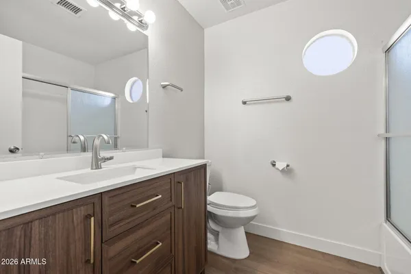 a bathroom with a sink a toilet and a mirror