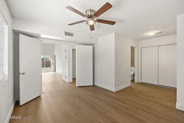 a view of a livingroom with a ceiling fan & wooden floor