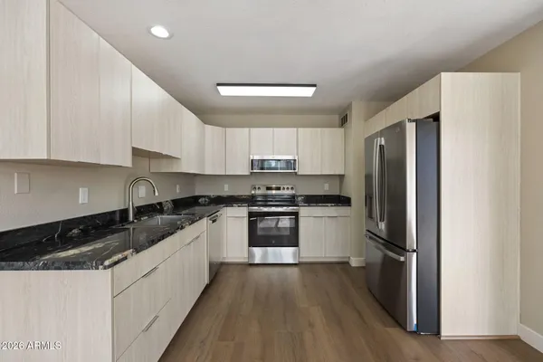 a kitchen with stainless steel appliances granite countertop a refrigerator and a stove top oven
