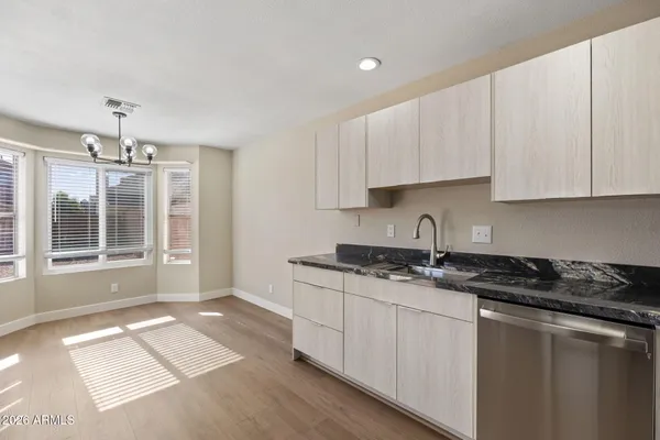 a kitchen with granite countertop a sink stove and cabinets