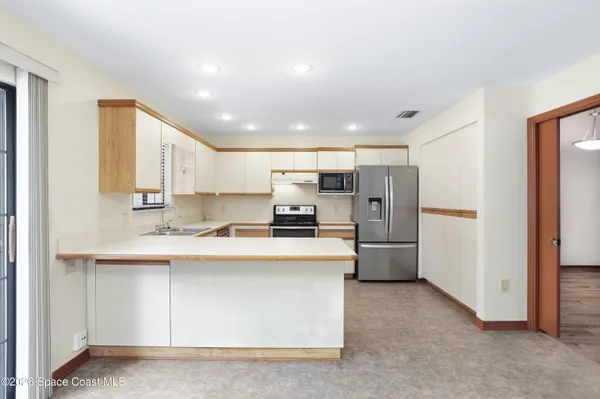 a kitchen with stainless steel appliances granite countertop a refrigerator a sink a stove top oven a sink and dishwasher