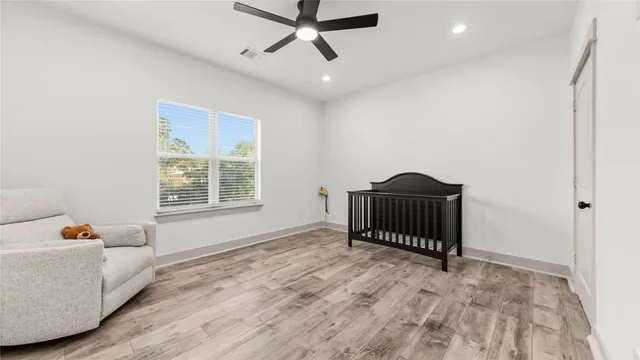 a bedroom with a bed and wooden floor
