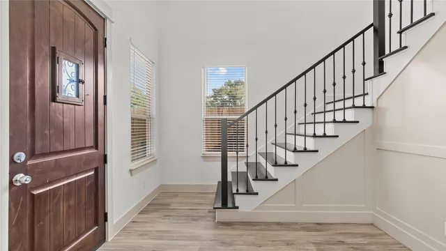 a view of entryway and hall with wooden floor