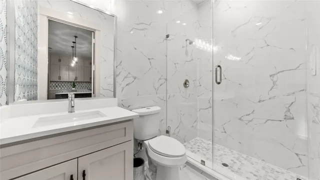 a bathroom with a sink a toilet and shower