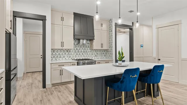a kitchen with stainless steel appliances a dining table chairs and wooden floor