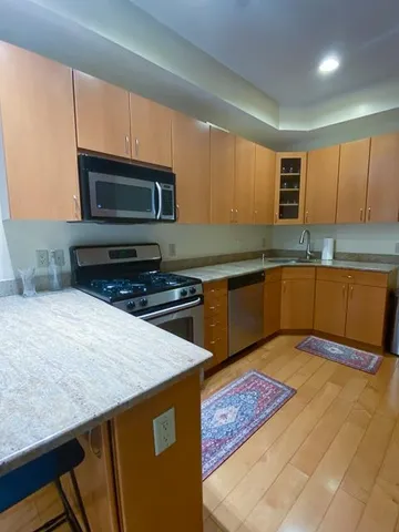 a kitchen with stainless steel appliances granite countertop a sink stove and microwave