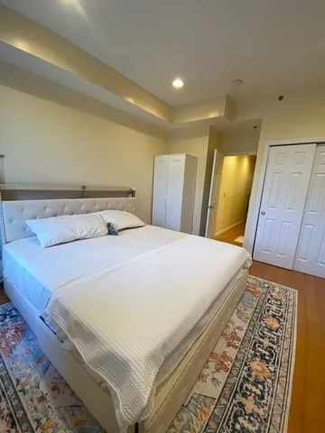 a bedroom with a bed and a mirror on dresser