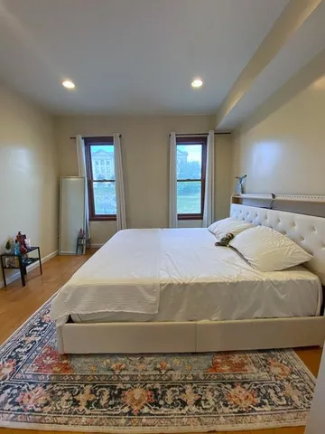 a bedroom with a bed and wooden floor