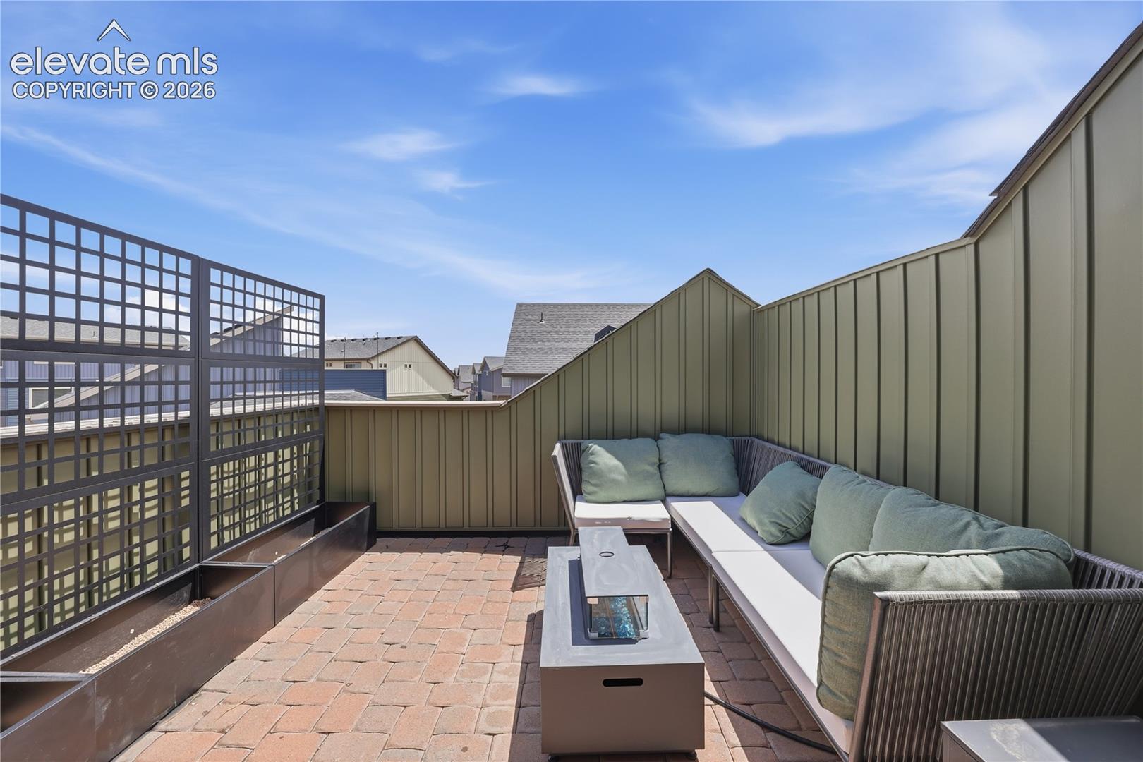 6008 Ashmore Road Colorado Springs, CO 80927 - Photo 42 of 48 Rooftop patio featuring brick paver flooring, a linear planter system, and a decorative privacy screen