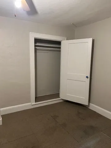 an empty room with closet and mirror