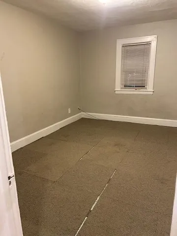 a view of a small space with wooden floor and a window