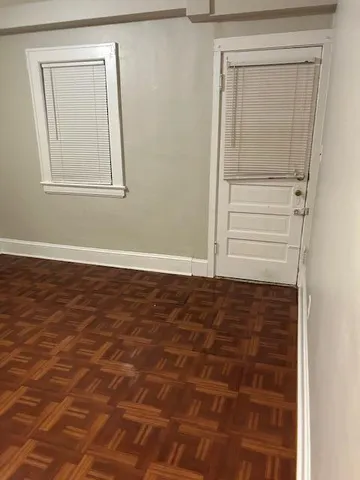 a view of a small space with wooden floor and a window