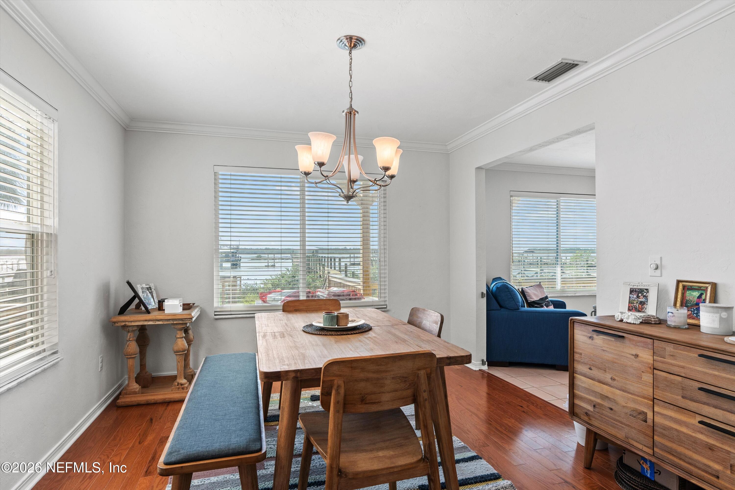 5532 Sunset Landing Circle St. Augustine, FL 32080 - Photo 15 of 43 a dining room with wooden floor and a chandelier