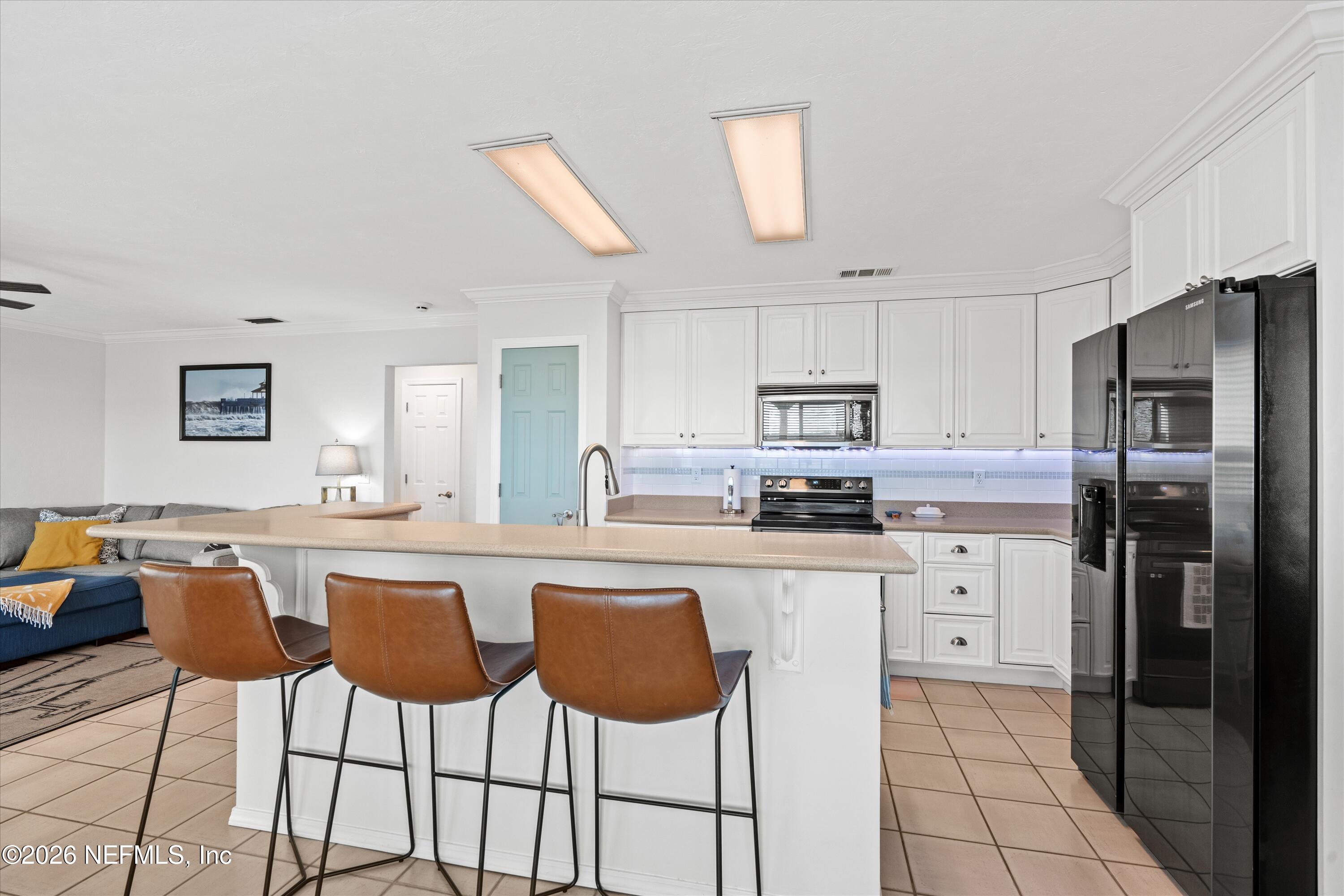 5532 Sunset Landing Circle St. Augustine, FL 32080 - Photo 21 of 43 a kitchen with stainless steel appliances granite countertop a stove a sink a refrigerator a dining table and chairs