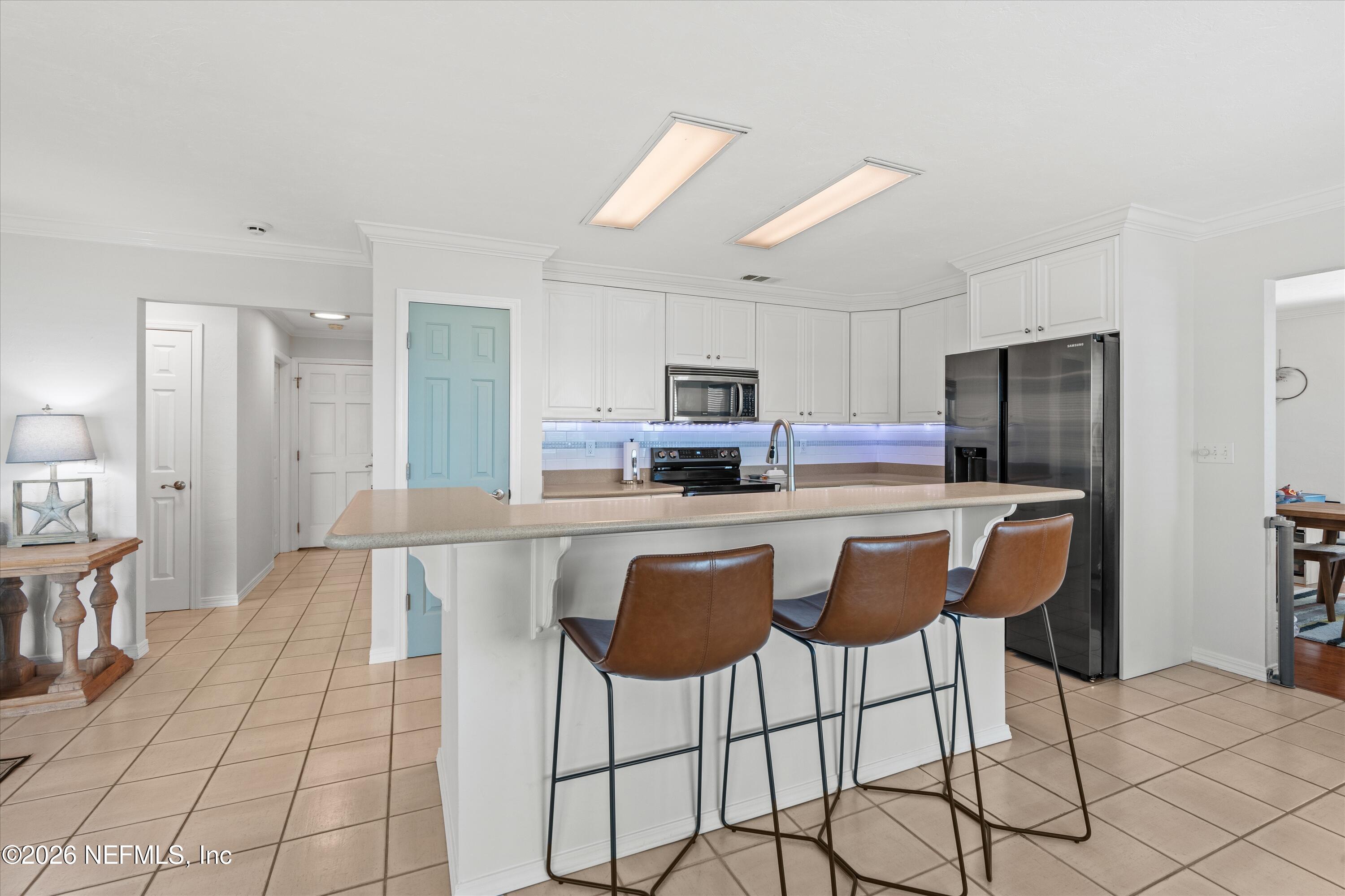 5532 Sunset Landing Circle St. Augustine, FL 32080 - Photo 22 of 43 a kitchen with stainless steel appliances kitchen island granite countertop a refrigerator and a stove top oven