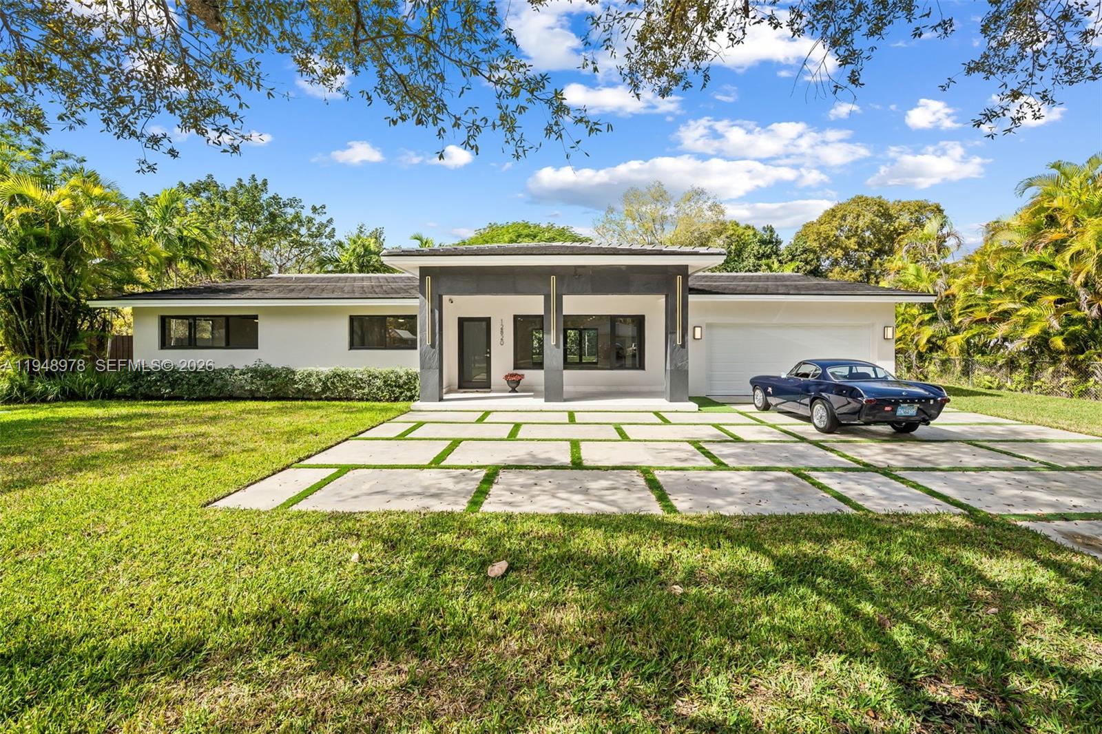 12820 Southwest 83rd Court Pinecrest, FL 33156 - Photo 1 of 38 a front view of a house with swimming pool and porch