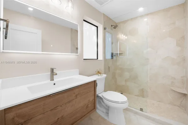 a bathroom with a sink a toilet and shower