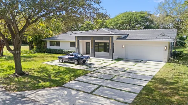 a view of a house with backyard sitting area and garden