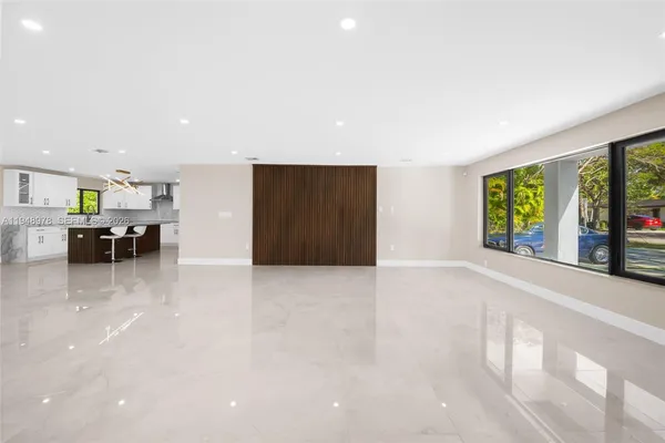 a view of an empty room with furniture and large window