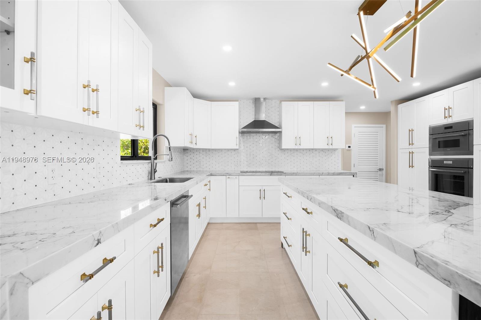 12820 Southwest 83rd Court Pinecrest, FL 33156 - Photo 8 of 38 a large kitchen with stainless steel appliances kitchen island granite countertop a sink and cabinets