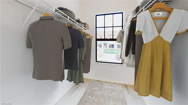a view of walk in closet with clothes and shoes
