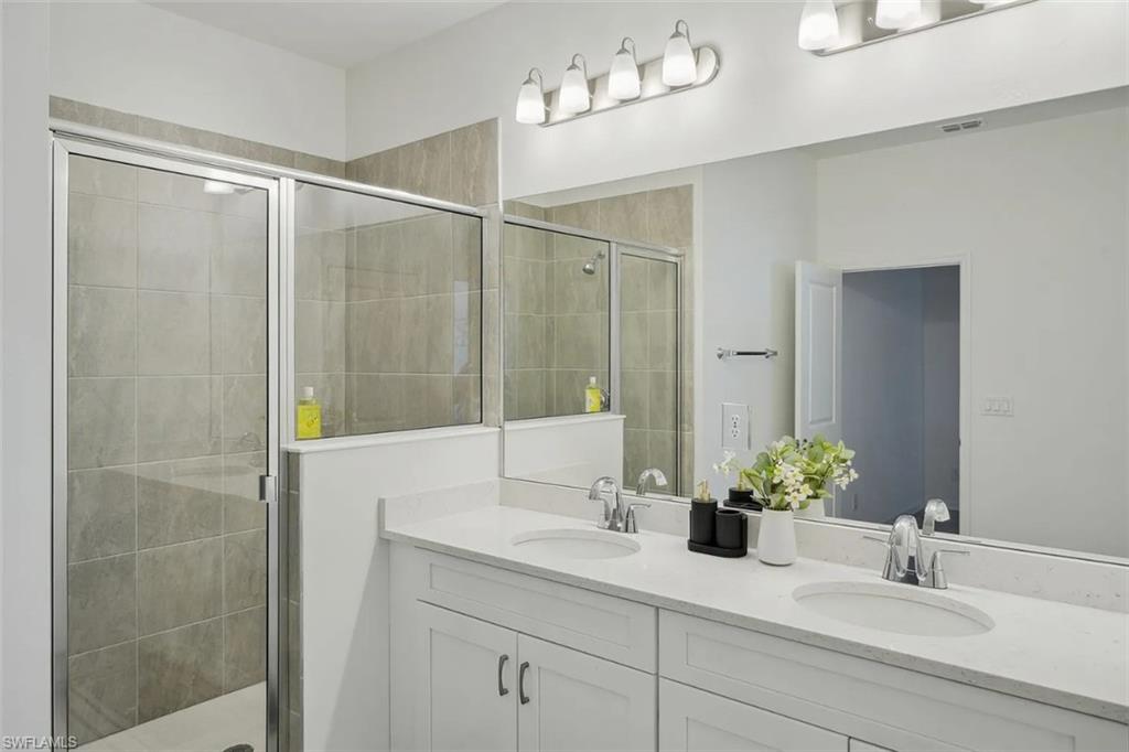 3134 Juniper Way Naples, FL 34112 - Photo 15 of 28 Full bath with double vanity and a stall shower