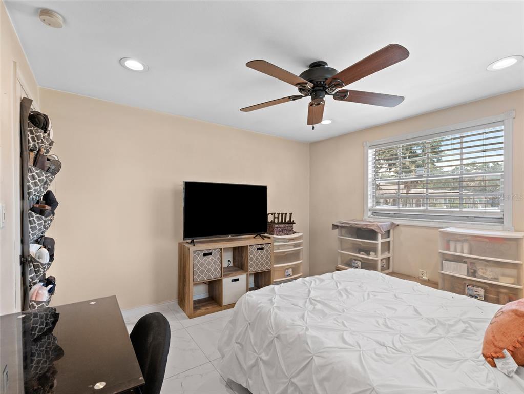 4237 Redcliff Place New Port Richey, FL 34652 - Photo 20 of 25 a bedroom with a bed and a flat screen tv