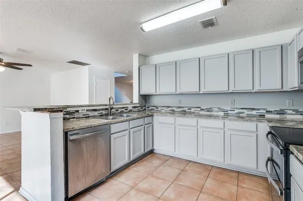 a kitchen with stainless steel appliances granite countertop a stove sink and cabinets