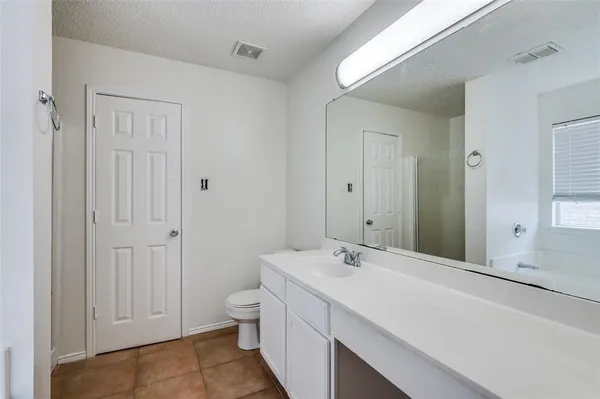 a spacious bathroom with a double vanity sink a toilet and a shower