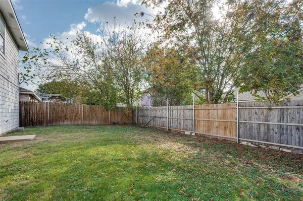 a view of a yard with wooden fence