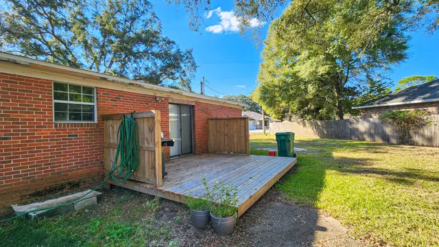 a view of a house with backyard and a tree