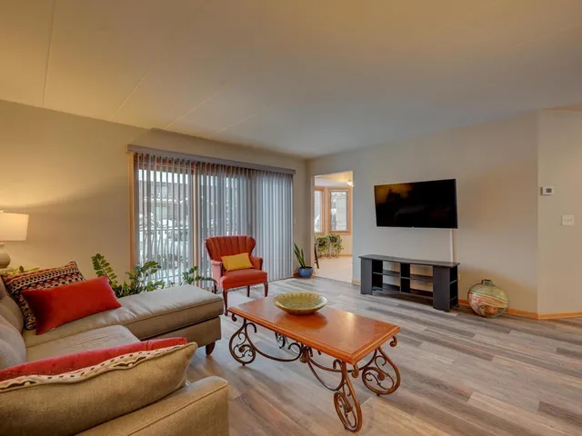 a living room with furniture a flat screen tv and a window