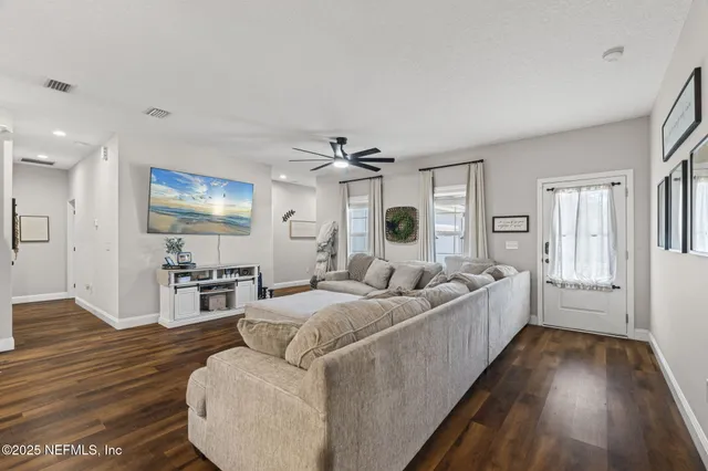 a living room with furniture and a wooden floor