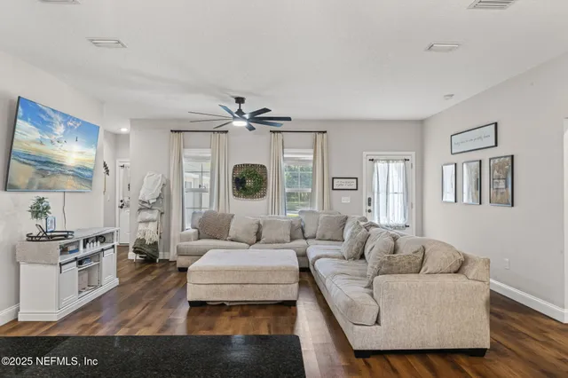 a living room with furniture and wooden floor