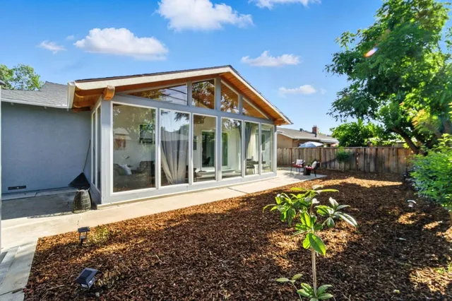 a view of a house with backyard and sitting area