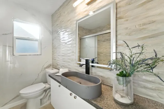 a bathroom with a toilet a sink and mirror