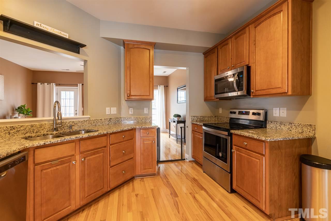 3111 Winding Waters Way Raleigh, NC 27614 - Photo 2 of 24 a kitchen with stainless steel appliances granite countertop wooden cabinets a stove top oven a sink and dishwasher