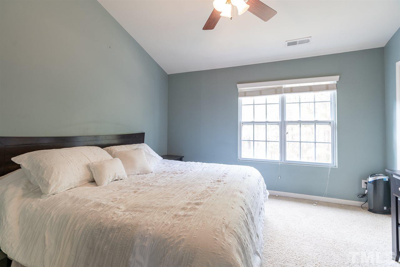 3111 Winding Waters Way Raleigh, NC 27614 - Photo 15 of 24 a bedroom with a bed and a chandelier