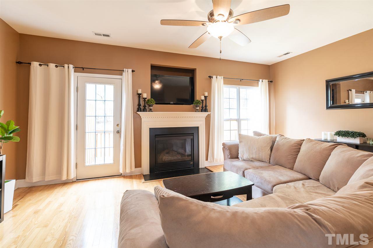 3111 Winding Waters Way Raleigh, NC 27614 - Photo 6 of 24 a living room with furniture a flat screen tv and a fireplace