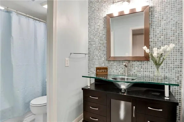 a bathroom with a sink a toilet and mirror